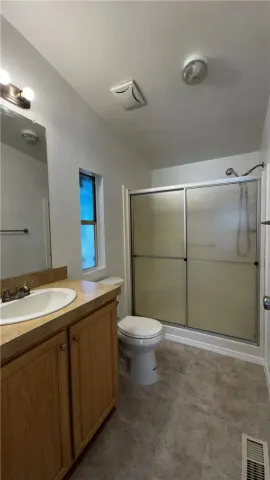 a bathroom with a granite countertop sink toilet and a mirror
