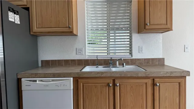 a kitchen with granite countertop a sink and a white cabinets