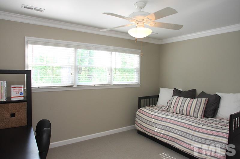 6308 Wynbrook Way Raleigh, NC 27612 - Photo 14 of 21 a bedroom with a bed and a chandelier