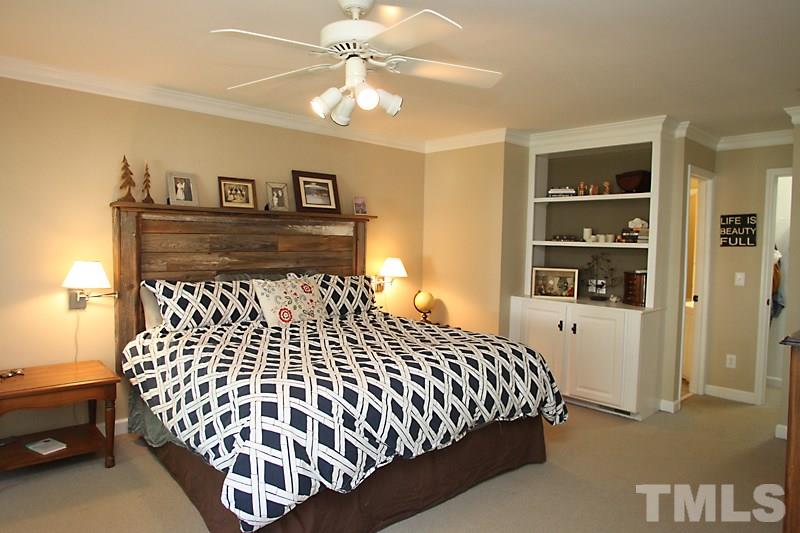 6308 Wynbrook Way Raleigh, NC 27612 - Photo 9 of 21 a bedroom with a large bed and a chandelier