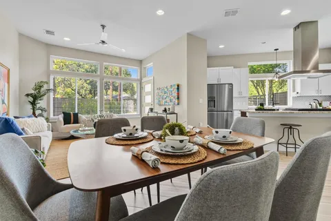 a view of a dining room with furniture large windows and wooden floor