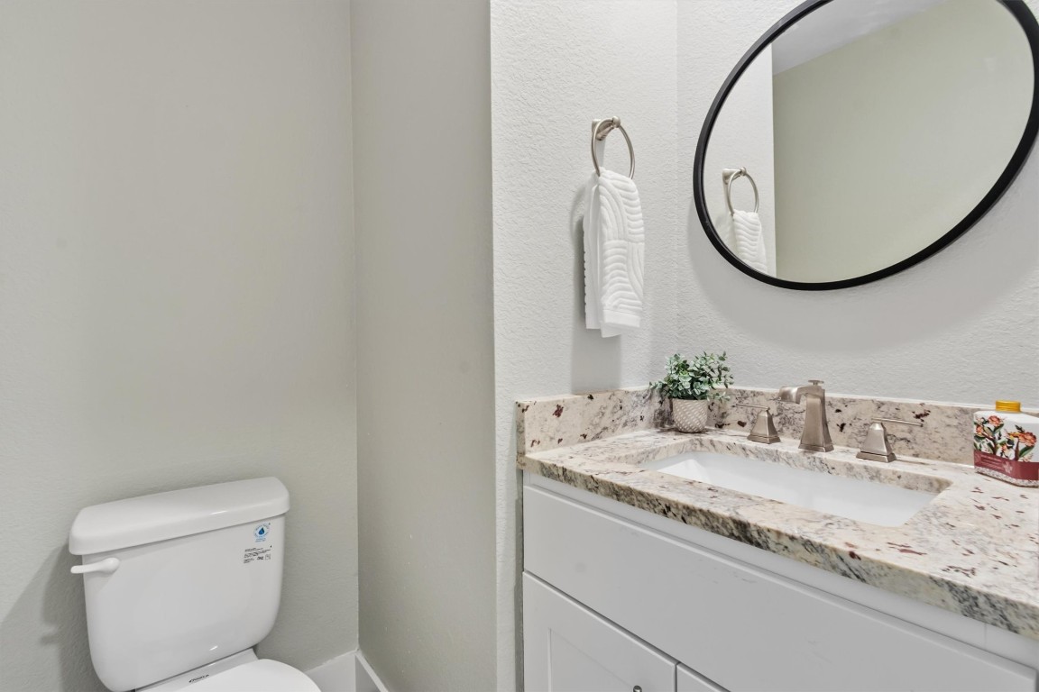 5609 Tura Lane, Unit A Austin, TX 78721 - Photo 19 of 39 a bathroom with a granite countertop sink and a mirror