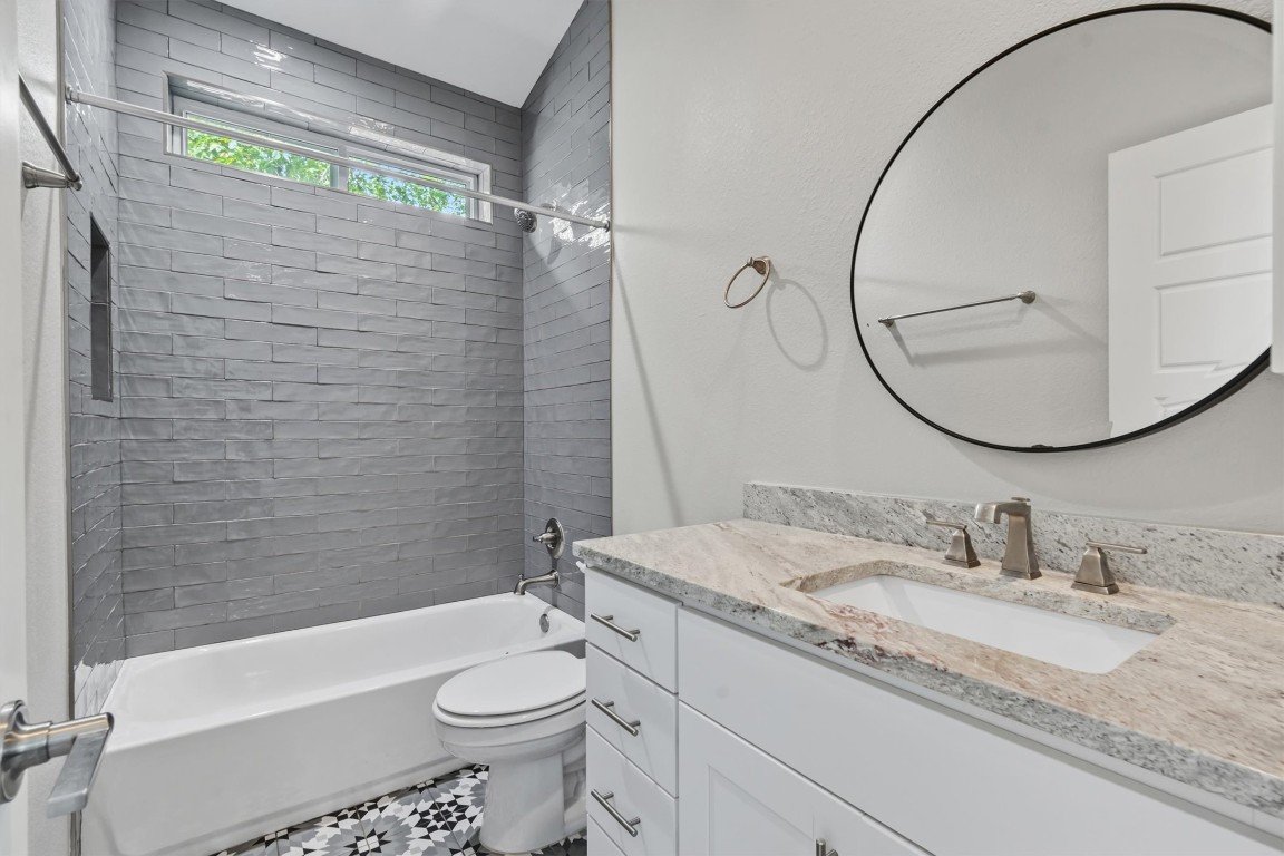 5609 Tura Lane, Unit A Austin, TX 78721 - Photo 31 of 39 a bathroom with a granite countertop sink toilet and shower