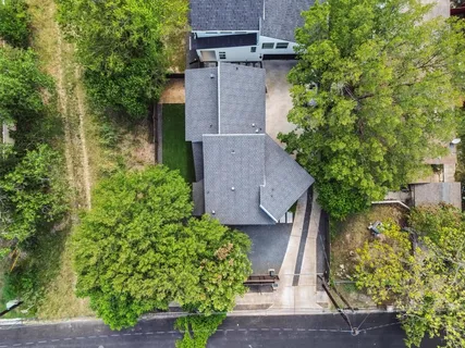 an aerial view of a house with a yard and large tree