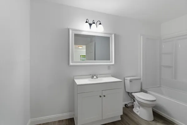 a bathroom with a sink vanity mirror and toilet