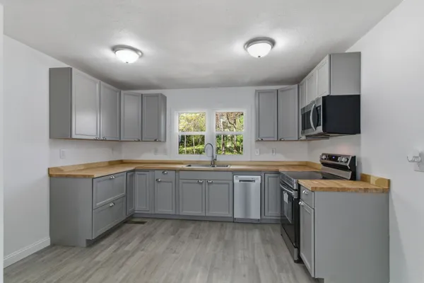 a kitchen with sink stove and microwave