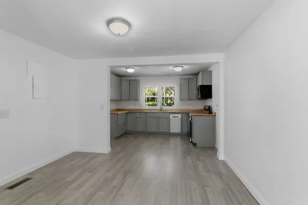 a kitchen with a sink cabinets and wooden floor