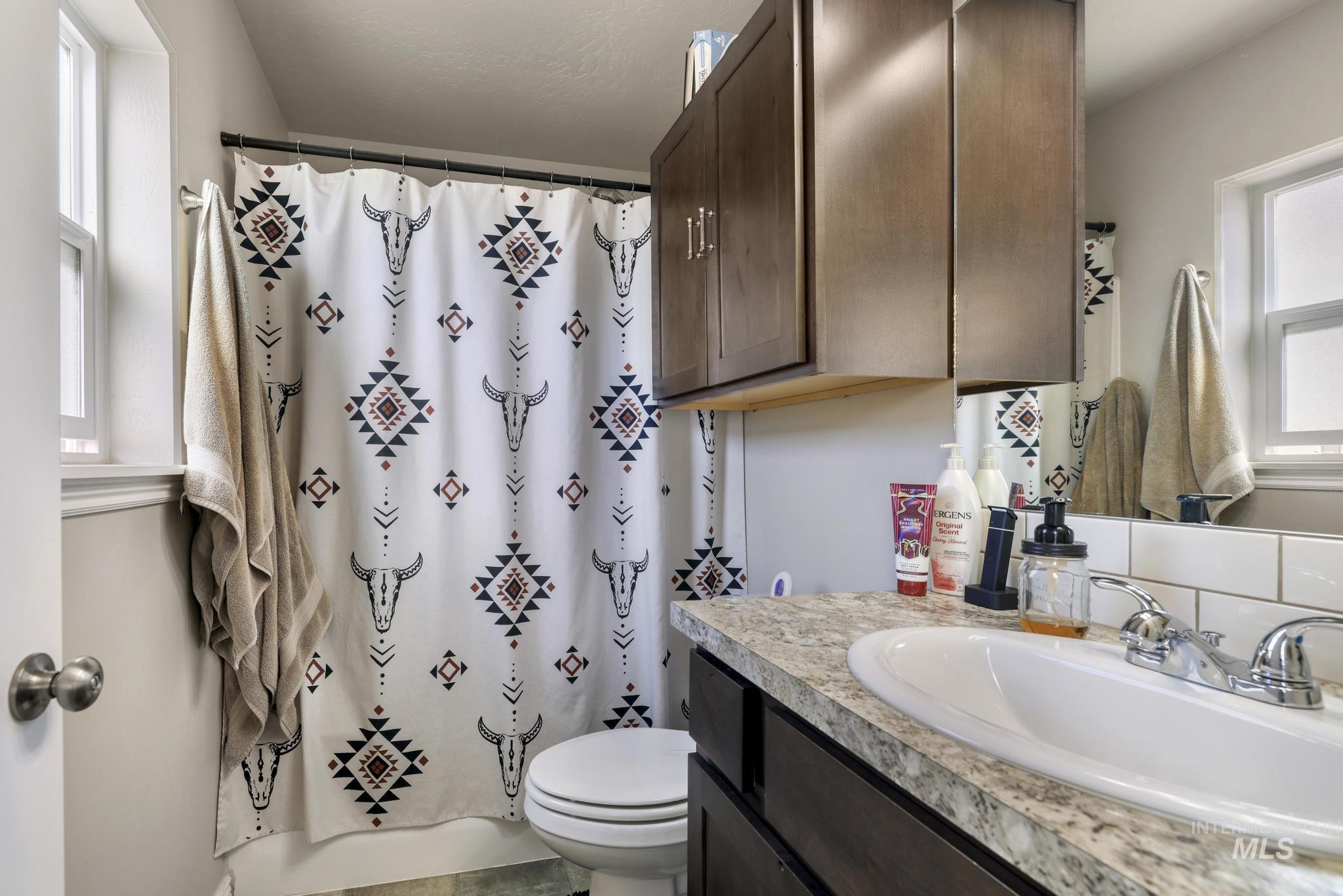 610 South B Street Rupert, ID 83350 - Photo 21 of 26 Bathroom with healthy amount of natural light, vanity, and shower / bath combination with curtain