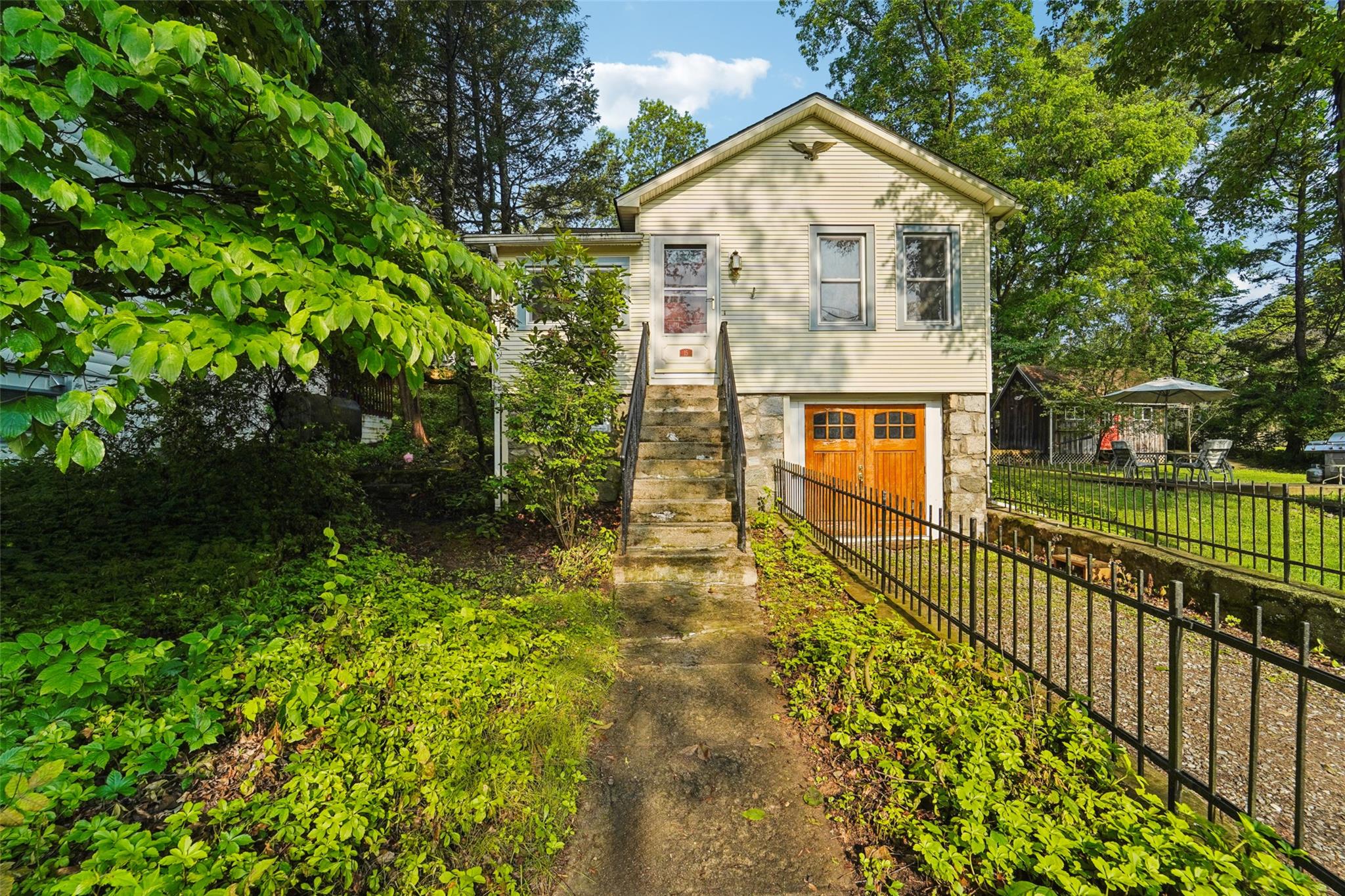 a view of a house with a small yard plants and large tree