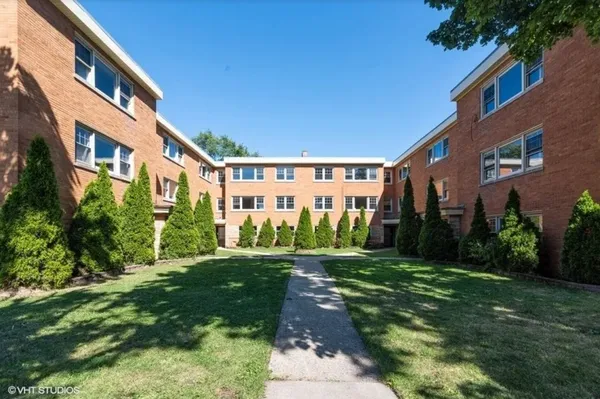 a view of a big yard in front of a brick building