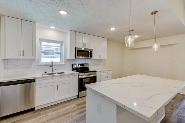 a kitchen with a sink a window and stainless steel appliances