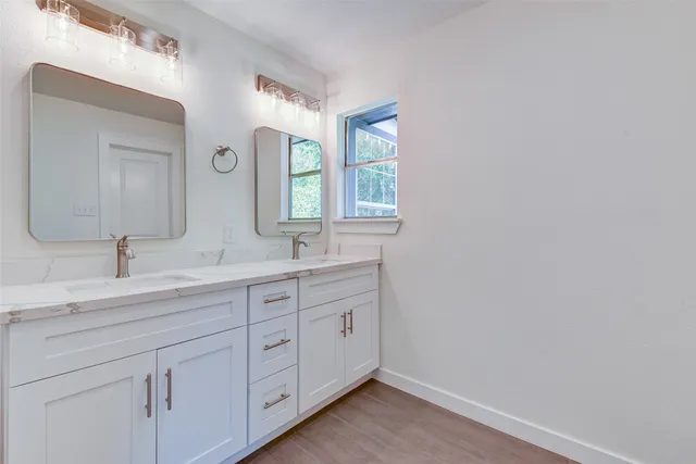 a bathroom with a double vanity sink and a mirror