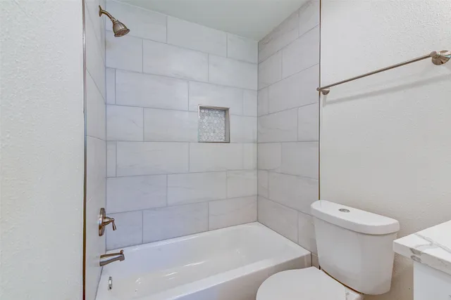 a white toilet and tub sitting next to a bathroom