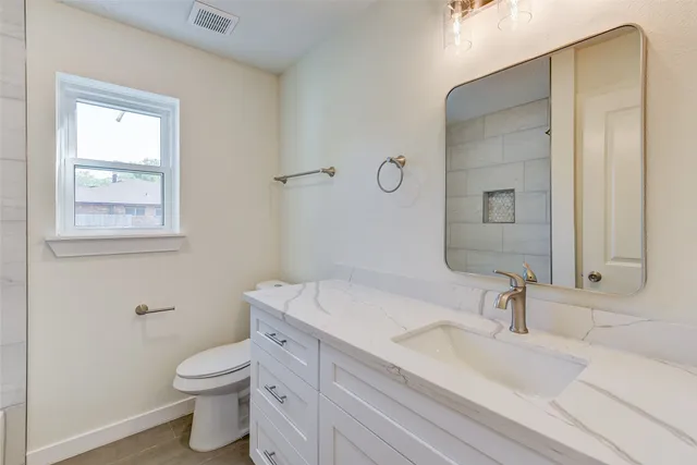 a bathroom with a sink a toilet and a mirror