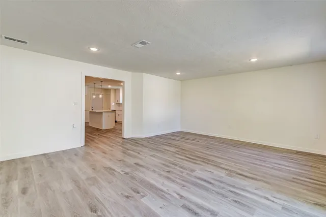 a view of empty room with wooden floor
