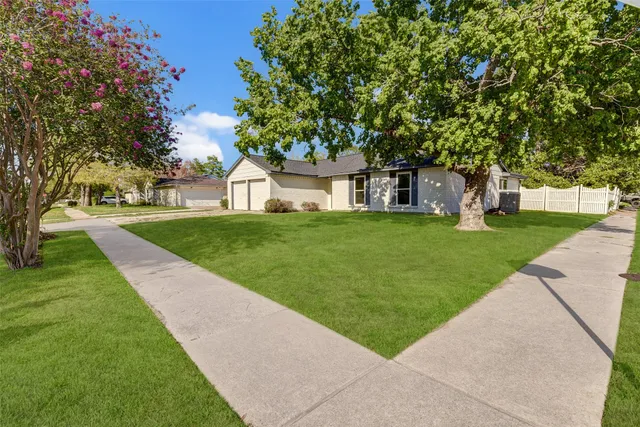 front view of a house with a yard and trees