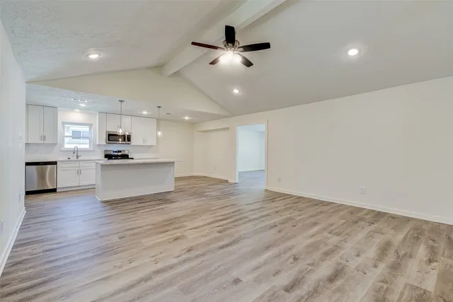 a view of kitchen with granite countertop cabinets and refrigerator