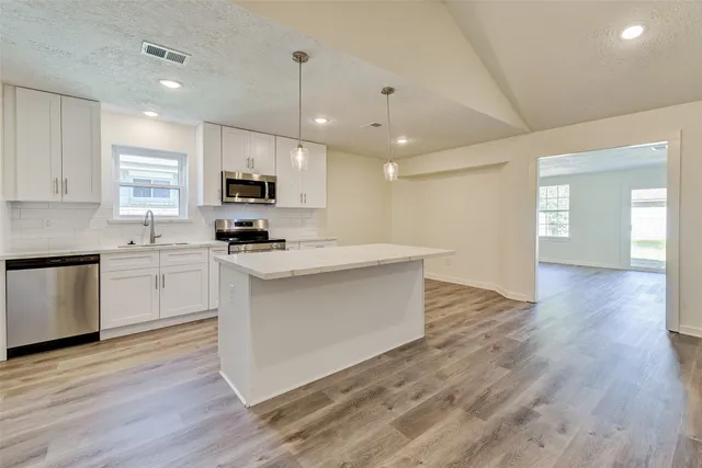 a kitchen with a sink cabinets and wooden floor