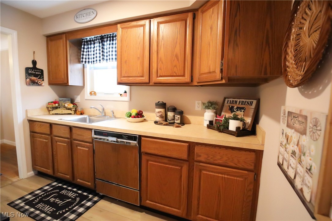 1344 Lander Road Cleveland, OH 44124 - Photo 9 of 49 Kitchen featuring light countertops, dishwasher, and brown cabinetry
