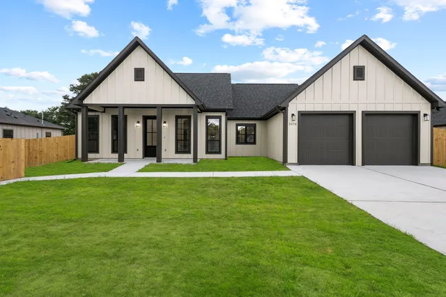 a front view of a house with a yard and trees