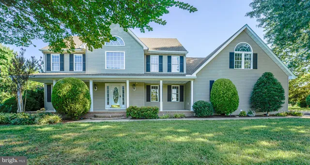 a front view of a house with a yard and trees