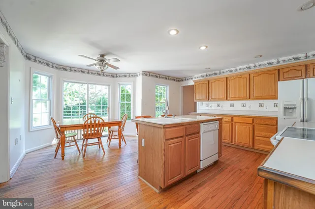 a kitchen with wooden floors and white appliances