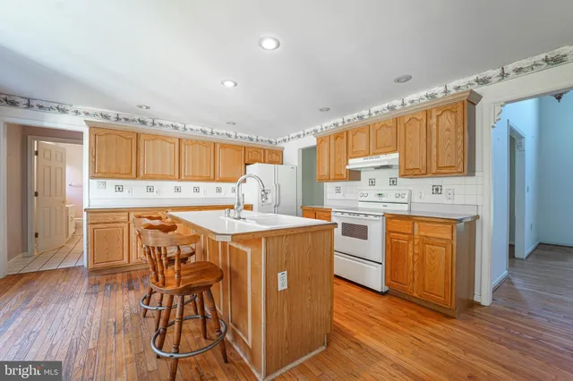 a kitchen with granite countertop wooden floors and white cabinets