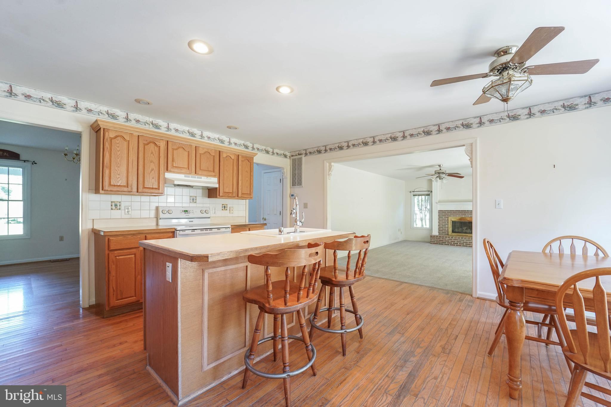 144 River Run Queenstown, MD 21658 - Photo 26 of 52 a kitchen with granite countertop wooden floors and white cabinets