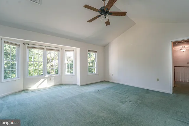 a view of an empty room with a ceiling fan