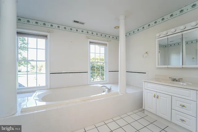 a spacious bathroom with a shower a mirror and a sink