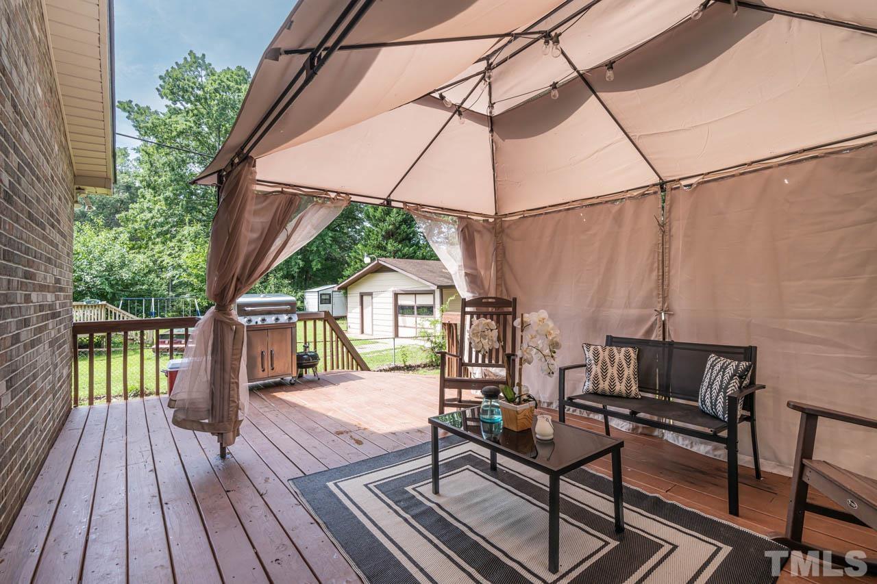 479 Ridgecrest Trail Henderson, NC 27537 - Photo 14 of 19 a view of deck with table and chairs under an umbrella with wooden floor