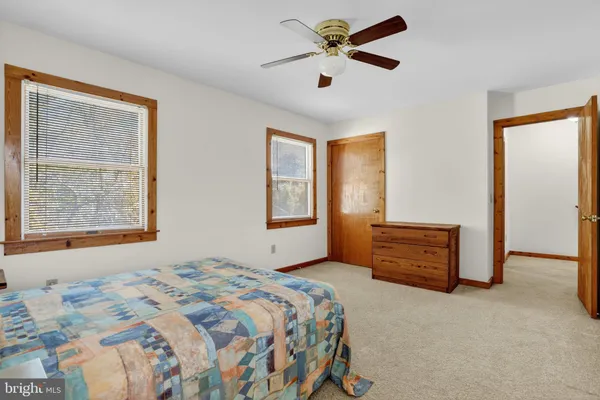 a bedroom with a bed closet and dresser