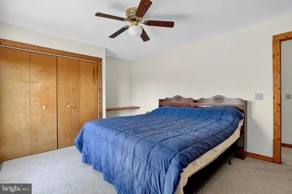 a bedroom with a bed and a ceiling fan