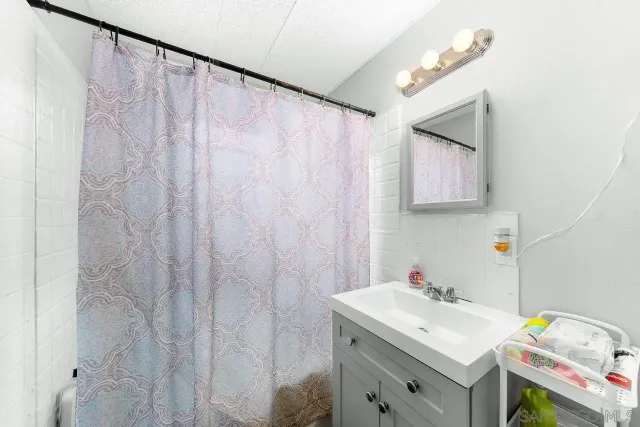 a bathroom with a sink vanity and a tub
