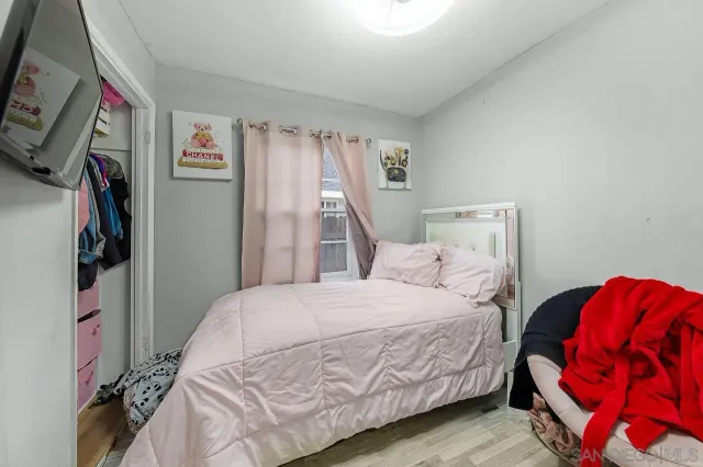 a bedroom with a large bed and a flat tv screen