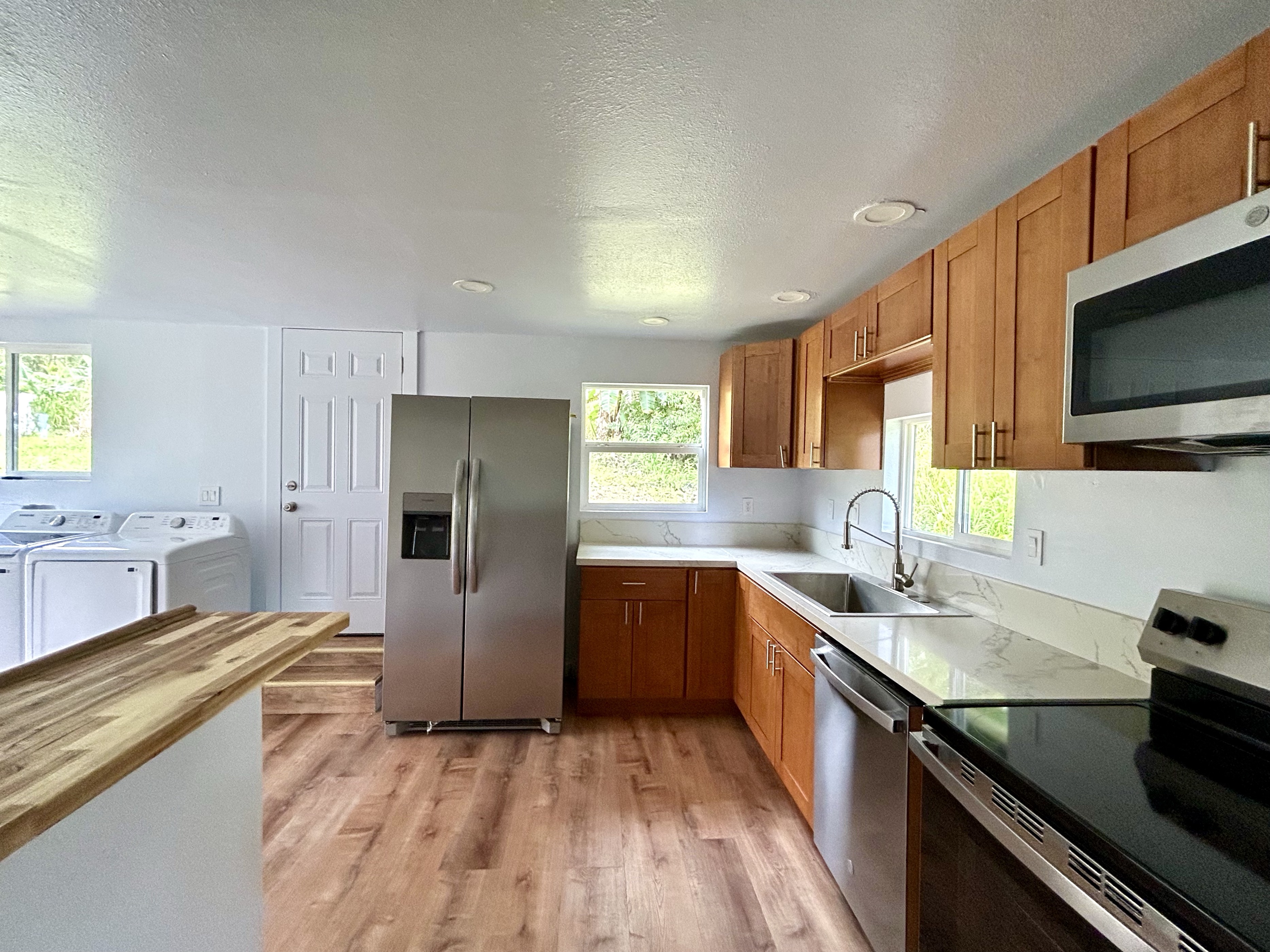 82-6136 D Road, Unit B Captain Cook, HI 96704 - Photo 14 of 30 a kitchen with granite countertop stainless steel appliances and wooden cabinets