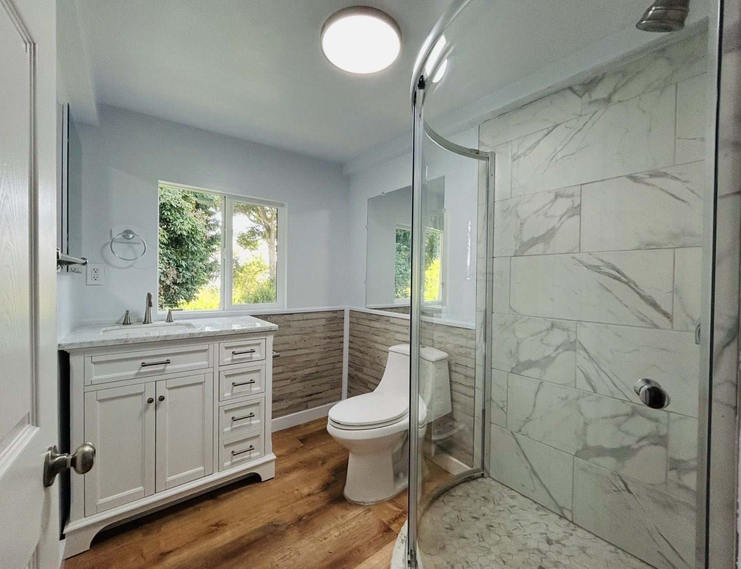 82-6136 D Road, Unit B Captain Cook, HI 96704 - Photo 4 of 30 a bathroom with a granite countertop toilet a sink a mirror a window and vanity