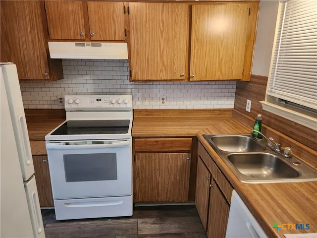 a kitchen with a sink stove and cabinets
