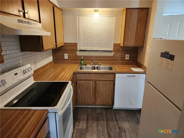 a kitchen that has a sink and a stove top oven