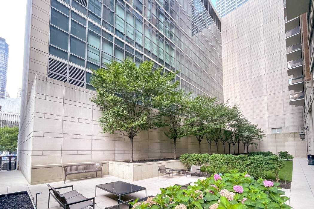 161 West 61st Street, Unit 15E Manhattan, NY 10023 - Photo 22 of 24 a backyard of a house with lots of green space and fountain