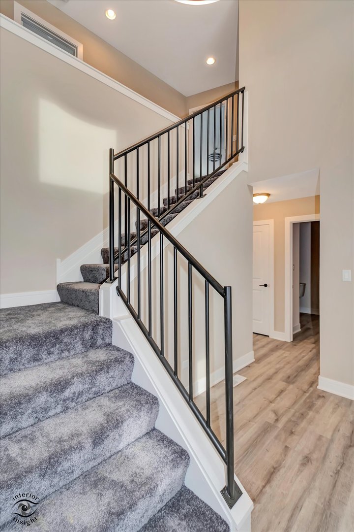 4996 Ribbon Drive Monee, IL 60449 - Photo 4 of 28 a view of staircase with lots of frames on wall and wooden floor