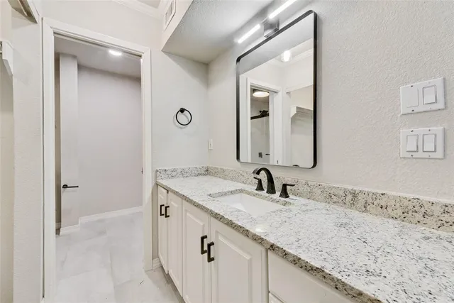 a bathroom with a granite countertop sink and a mirror