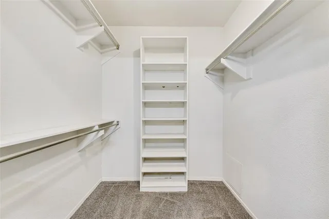 a view of walk in closet with empty racks