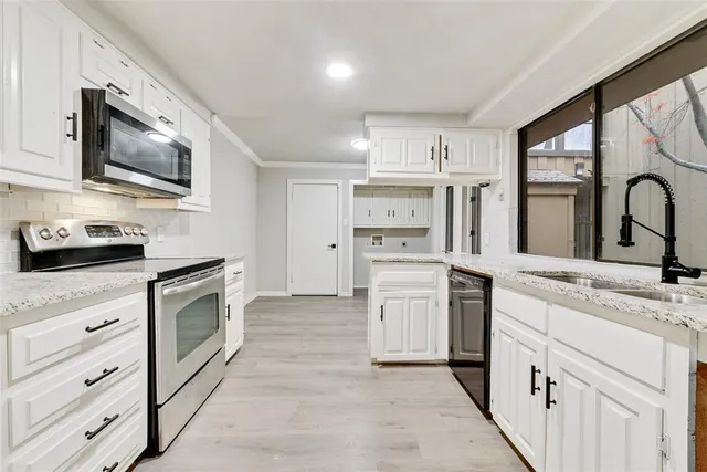 a kitchen with white cabinets and stainless steel appliances