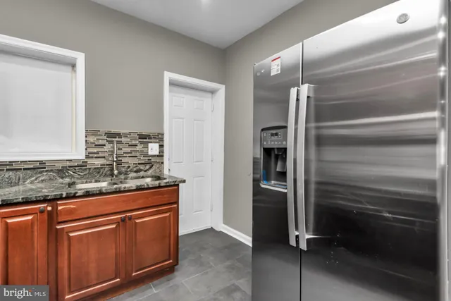 a kitchen with stainless steel appliances granite countertop a refrigerator and a sink