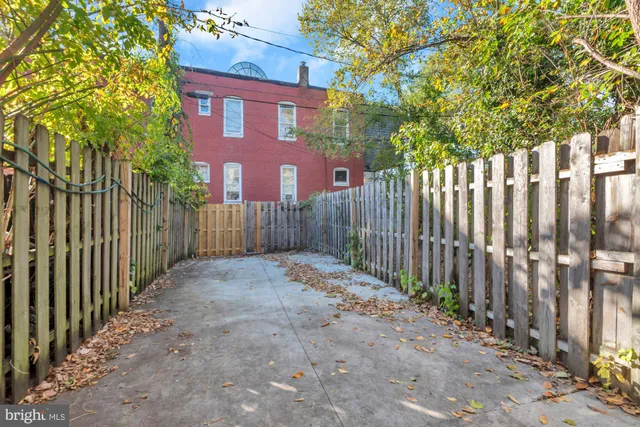 a view of a brick house with wooden fence