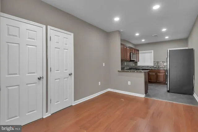a view of a kitchen with a sink and dishwasher a refrigerator with wooden floor