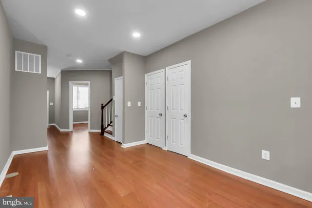 a view of empty room with wooden floor