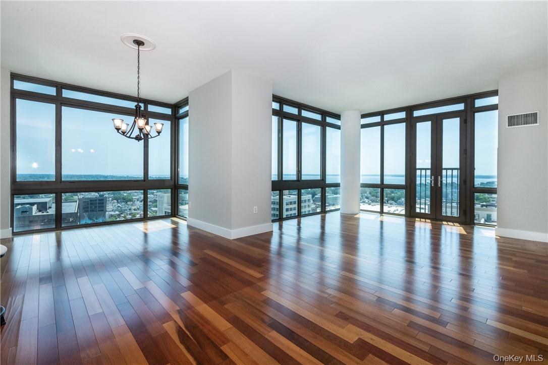 175 Huguenot Street, Unit 1802 New Rochelle, NY 10801 - Photo 1 of 31 a view of empty room with wooden floor and fan