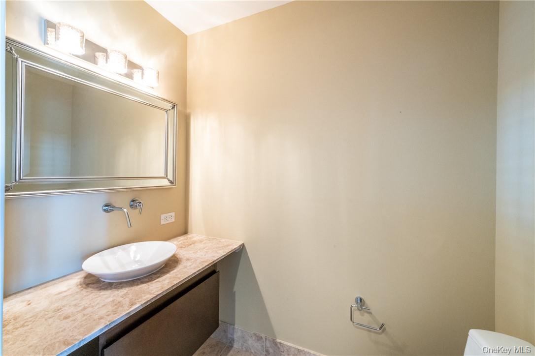 175 Huguenot Street, Unit 1802 New Rochelle, NY 10801 - Photo 14 of 31 a bathroom with a granite countertop sink and a mirror